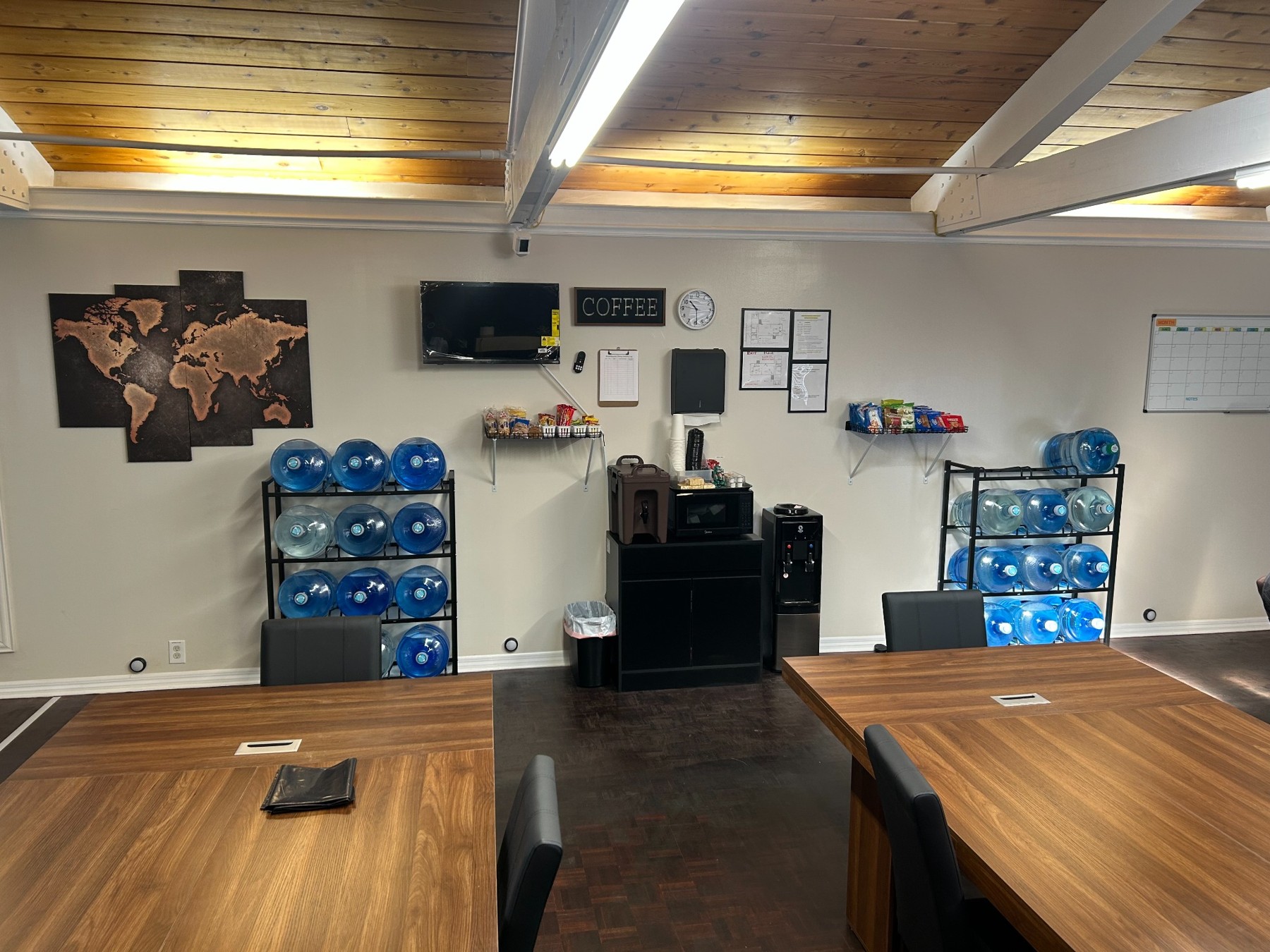 Dining area with wooden tables, bottled water dispensers, and a beverage station