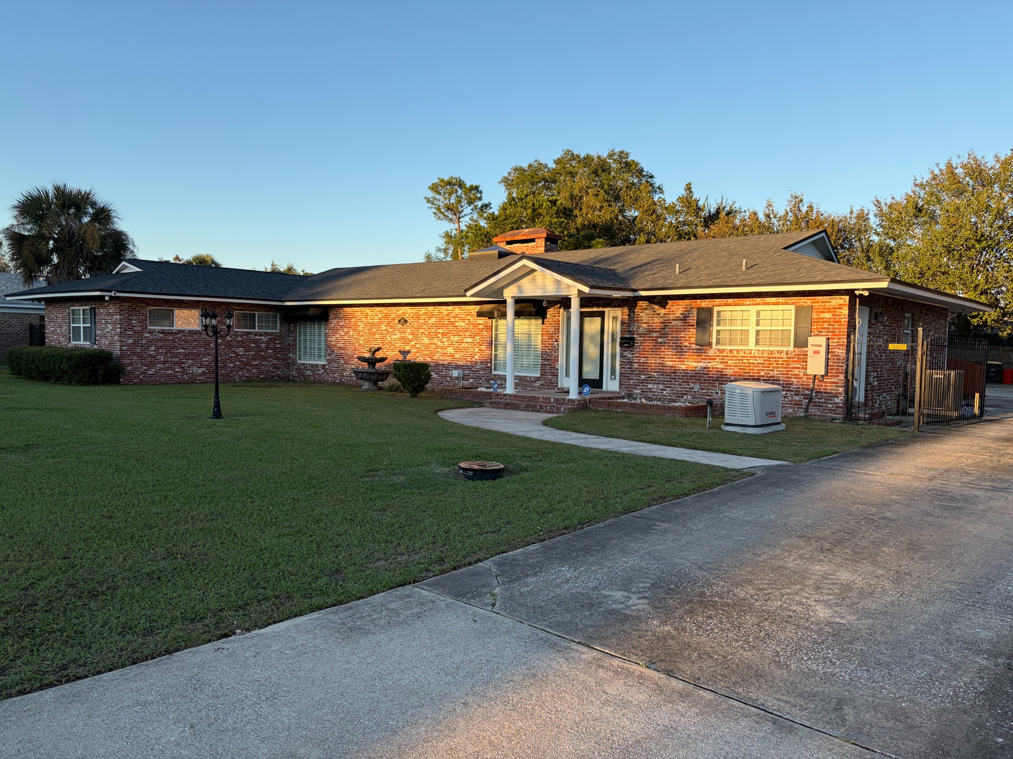 Royal Blue brick exterior with front lawn and a curving walkway